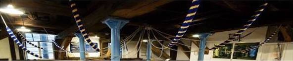 Church bells and their wooden frame, viewed from below inside the bell tower.