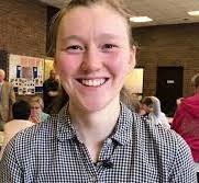 New curate smiles at the camera in a community setting