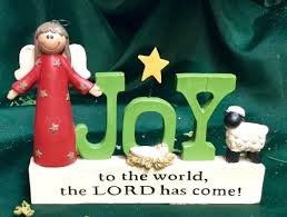 Christmas nativity scene with angel, sheep, and "Joy to the World" text