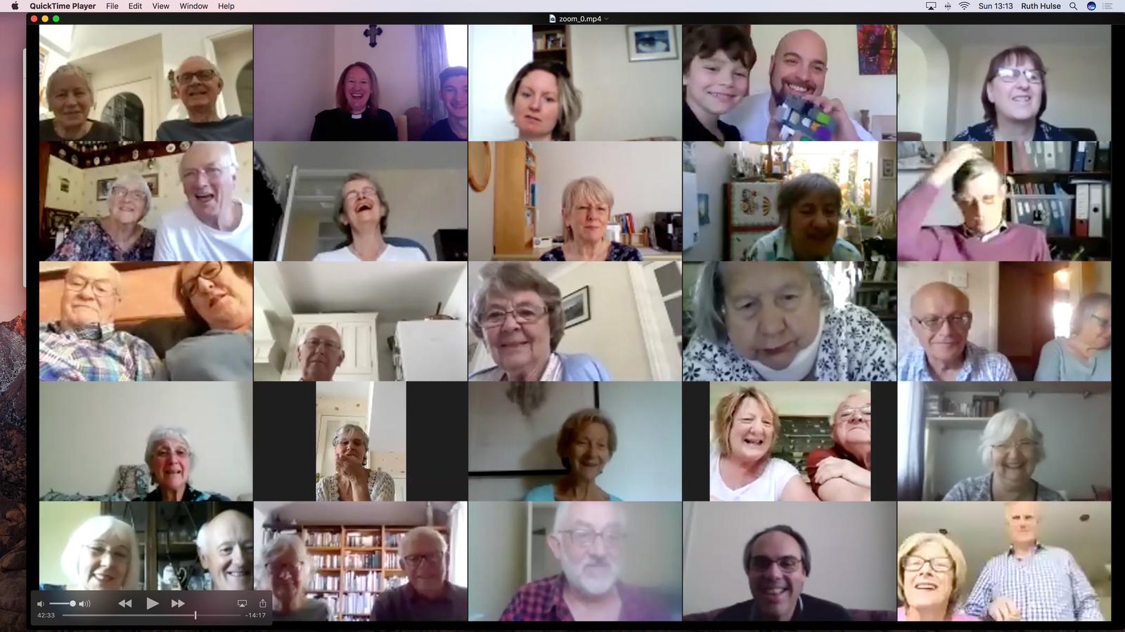 Screenshot of a Zoom video call grid showing around 25 participants, several raising mugs or cups.