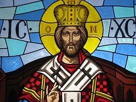 Stained glass of Christ the King wearing a crown and robes