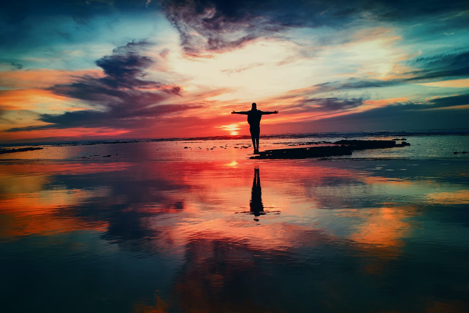 Silhouette Of Person Standing On Rock Surrounded By Body Of Water, from unsplash