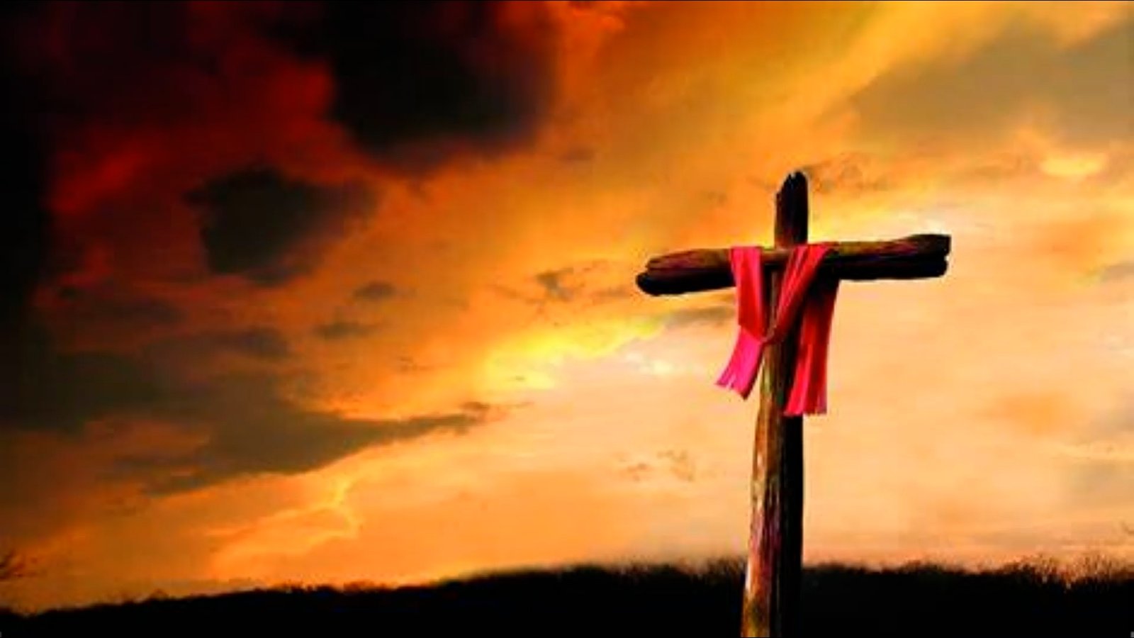 A wooden cross draped with a red cloth, set against a dramatic orange sunset sky.