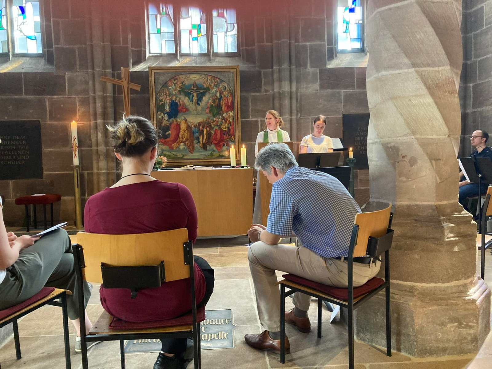 Group sitting in a church chapel during an informal service or prayer time, on a parish visit to Nuremberg.