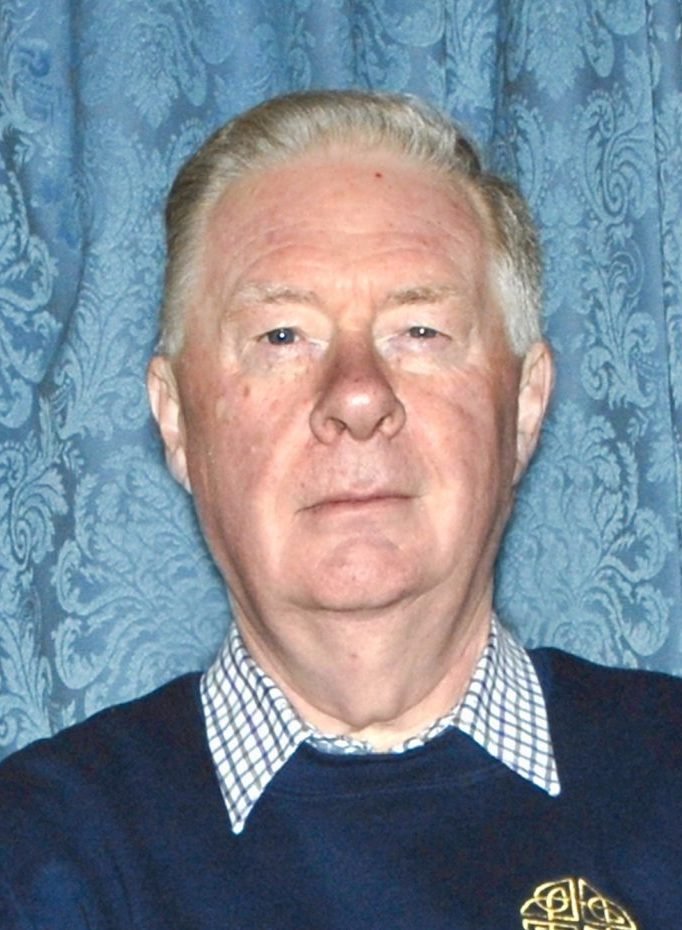 Portrait of Chris Pullin, a man with fair skin and graying hair, wearing a blue sweater.