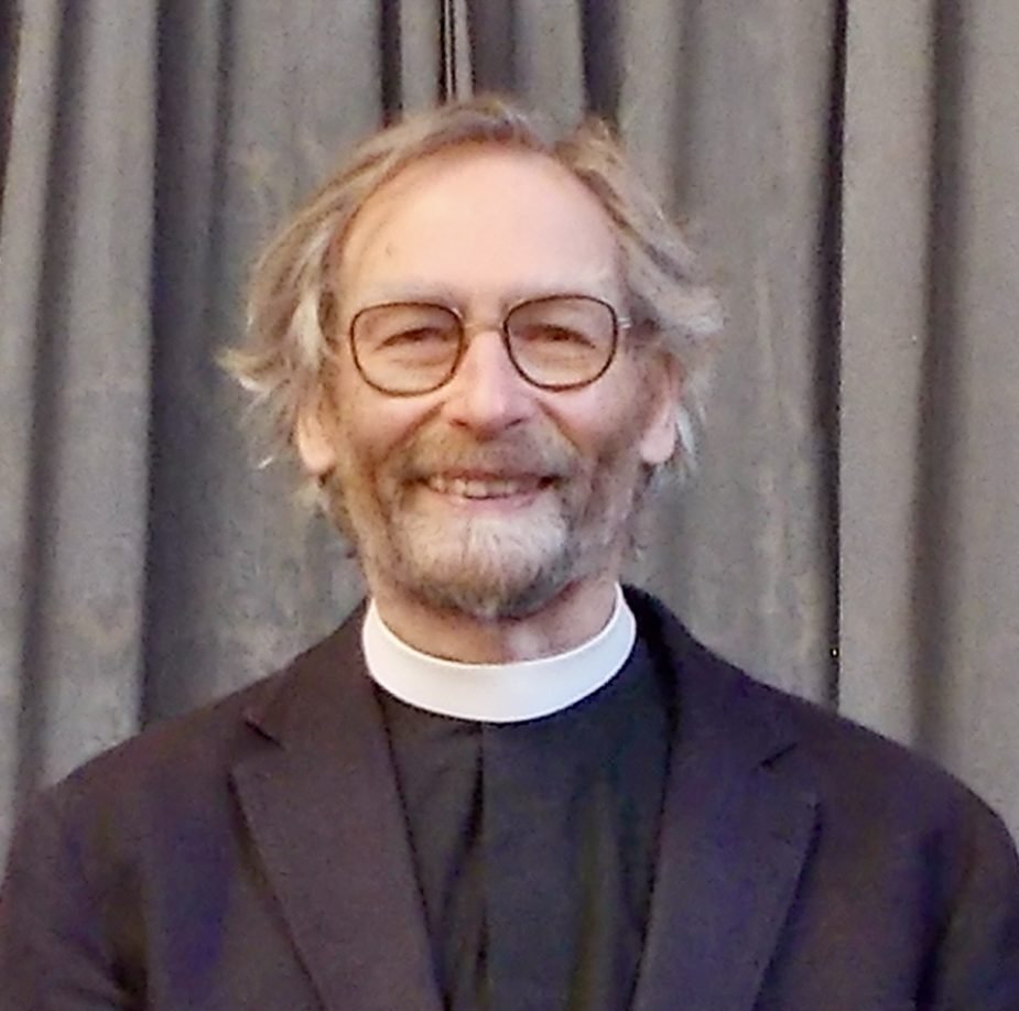 Reverend Sean Cathie wearing a clerical collar and glasses