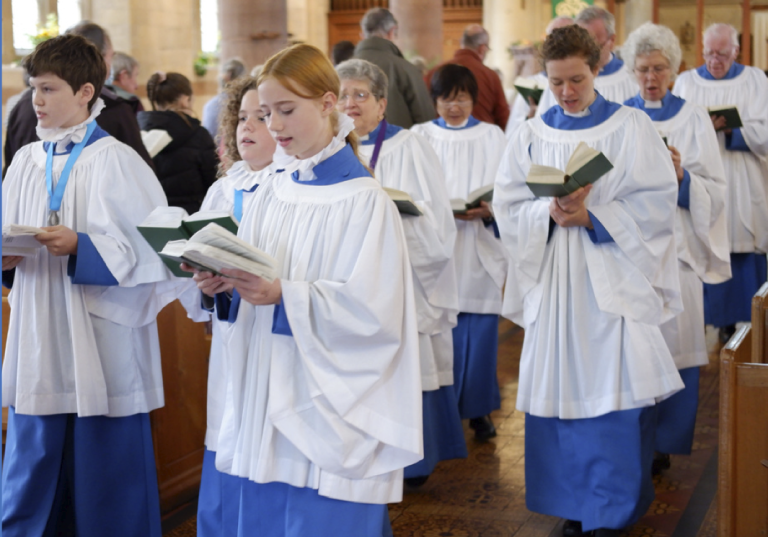 Children in choir robes holding hymn books in a church