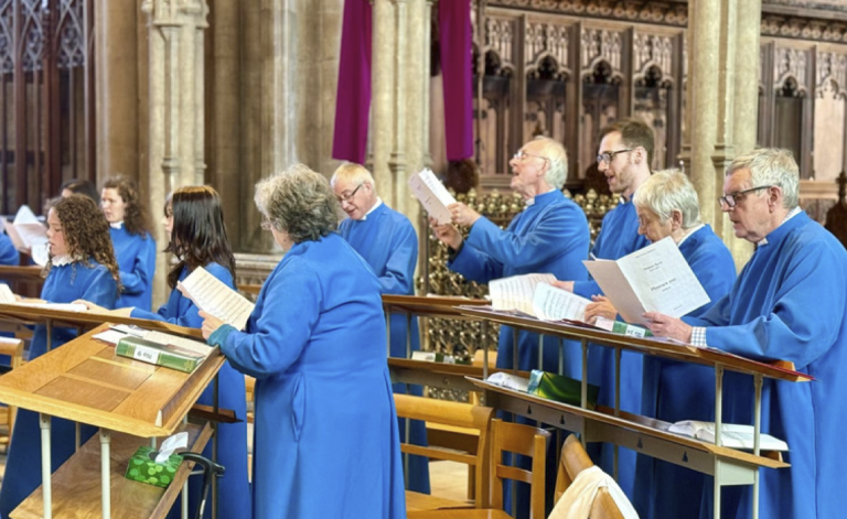 Choir members in blue robes singing in a church