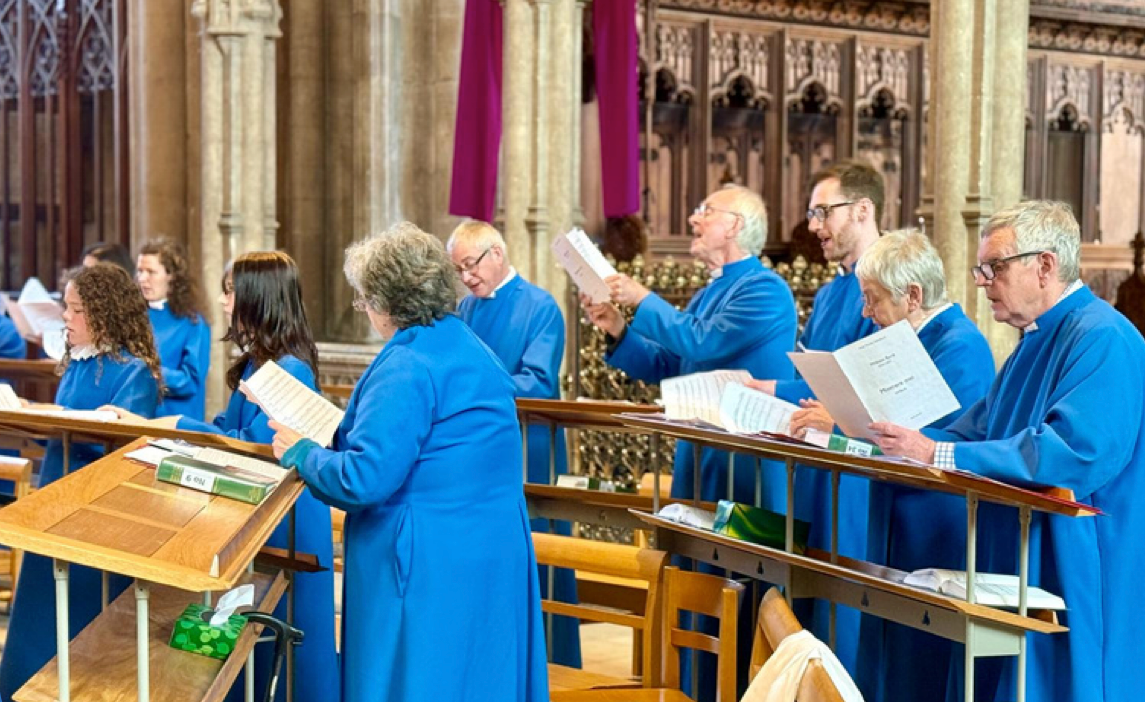 Choir members in blue robes singing in a church