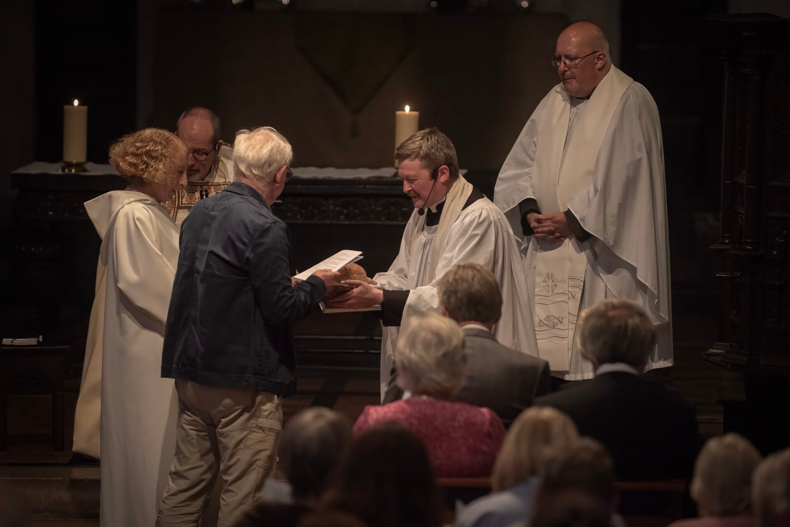 Parishioners presenting the symbols of ministry: a Bible, water, and bread and wine